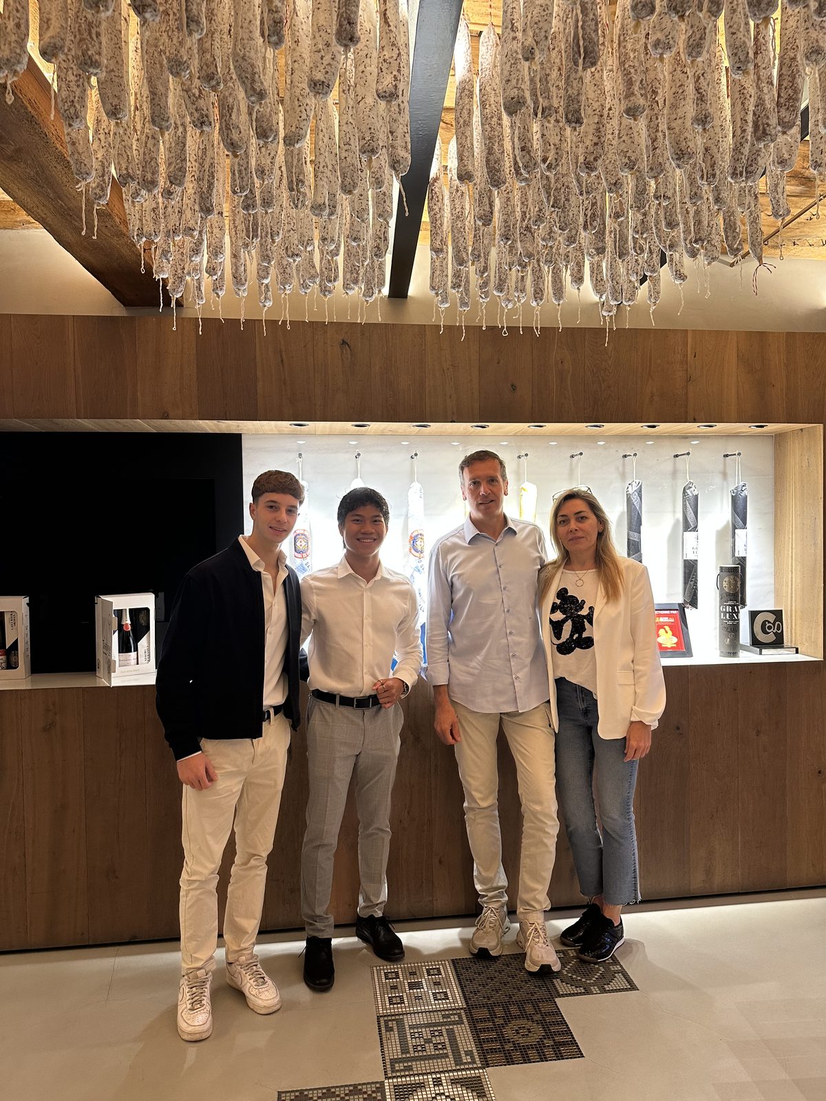 Parte del equipo de Nexe de visita en Casa Riera Ordeix, en Vic, bajo los fuets que se secan en el techo